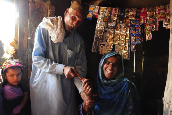 Hazoor takes some money for sweets, in her small corner shop in Pakistan. 